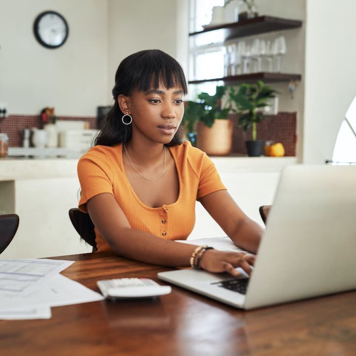 woman using laptop at kitchen table