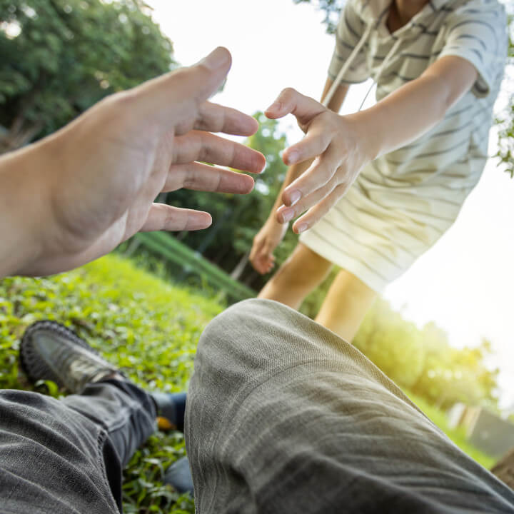 daughter extends hand to help father stand up after falling down