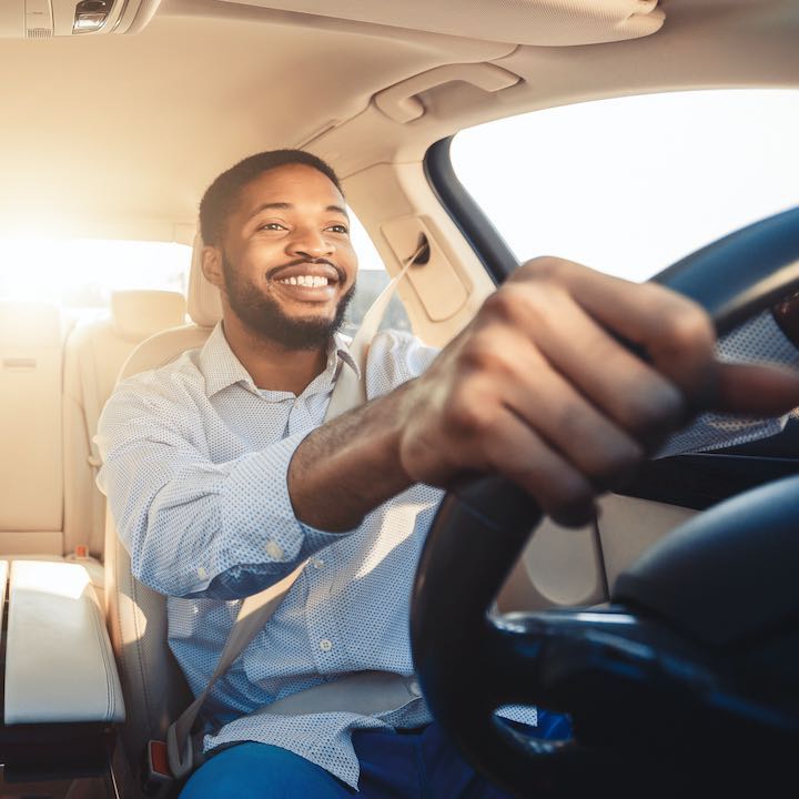 young couple smiling in new car