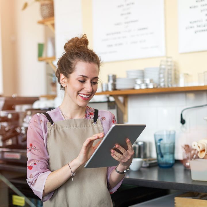 female business owner using tablet at bakery